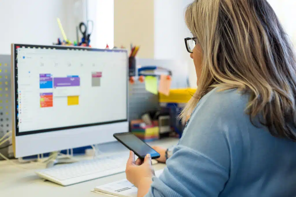 person-using-desktop-calendar-with-highlighted-appointment-dates